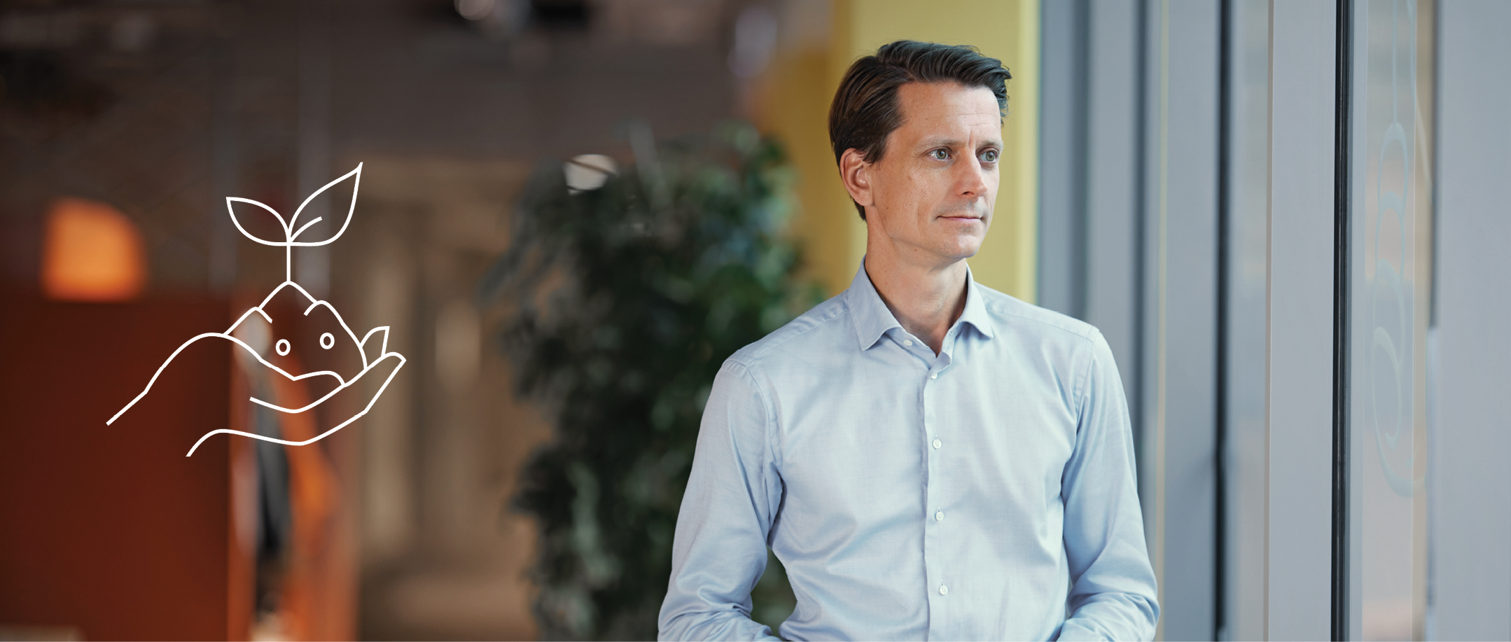 A person standing in front of an office window looking outside 