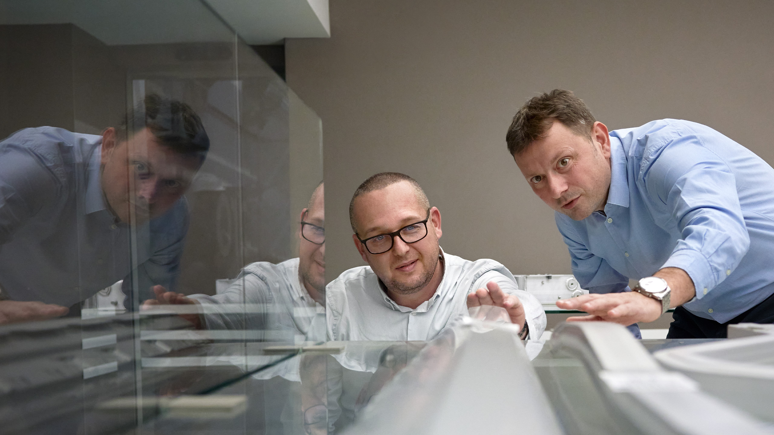 a group of men looking at a computer screen