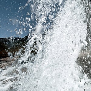 a large waterfall with snow on the sides
